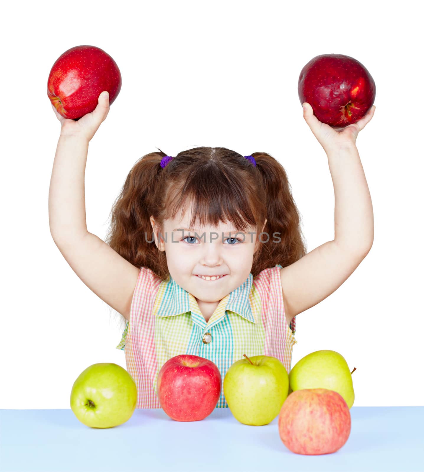 Girl playing with apples sitting at the table