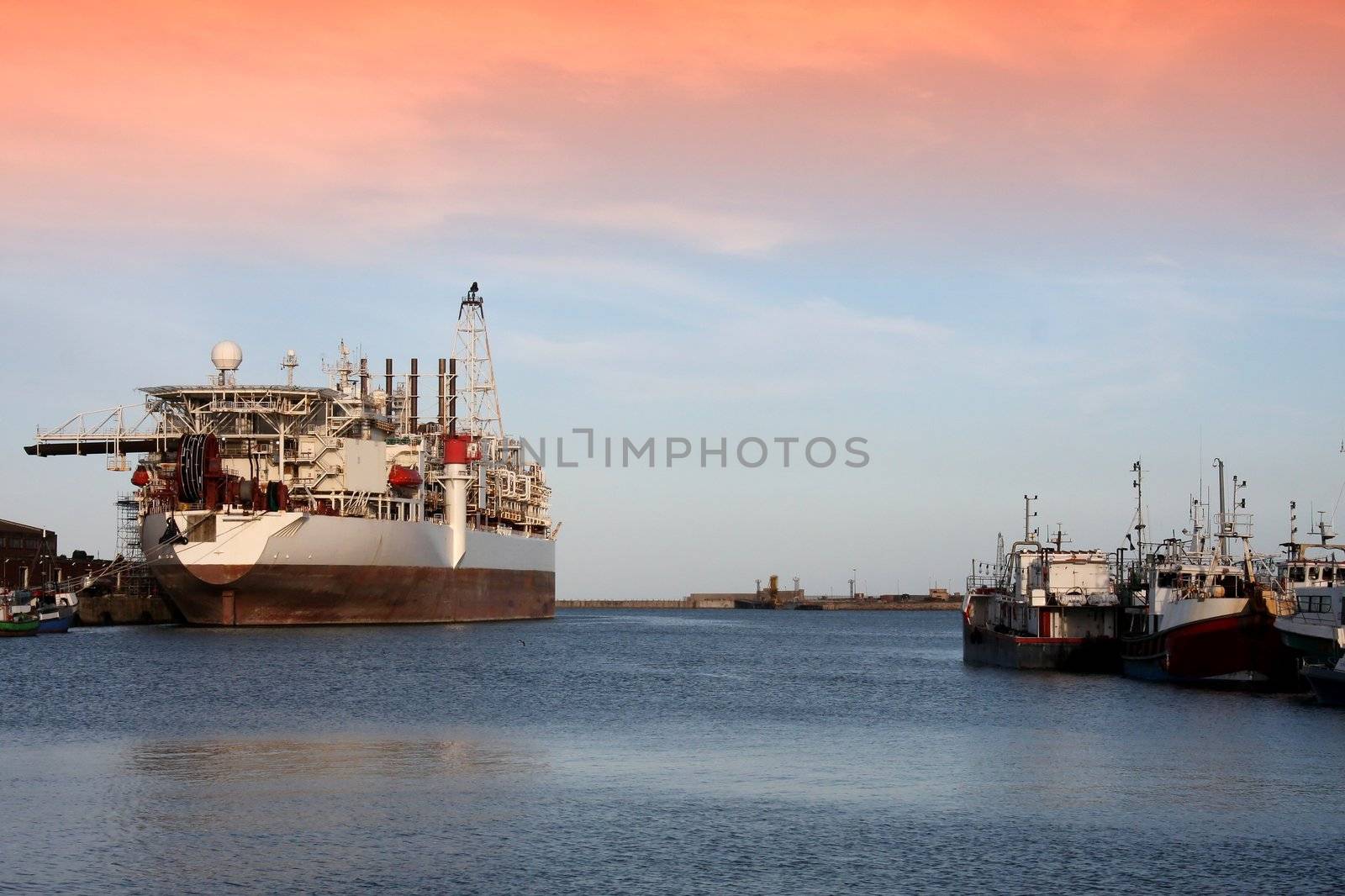 Oil processing ship and fishing boats in a habor