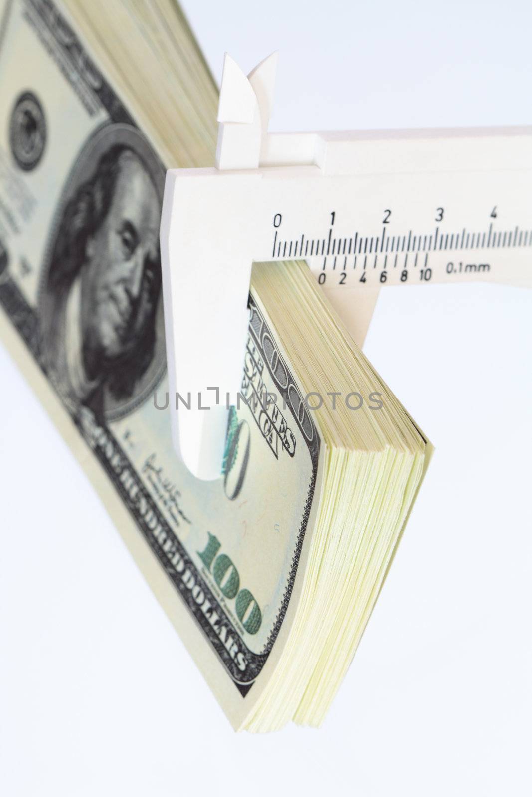 Bundle of one hundred dollar notes and vernier callipers on white background