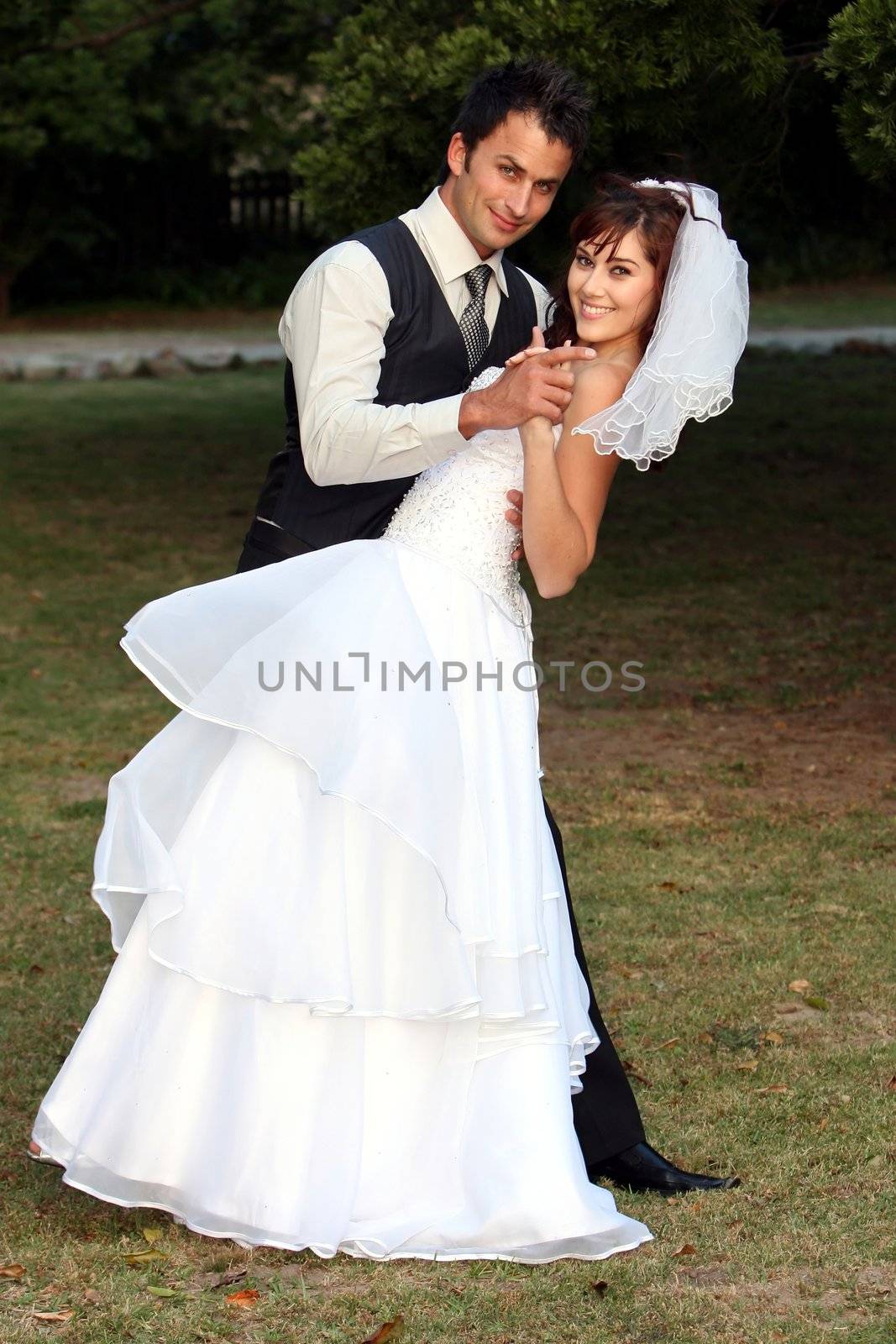 Beautiful wedding couple dancing on the lawn