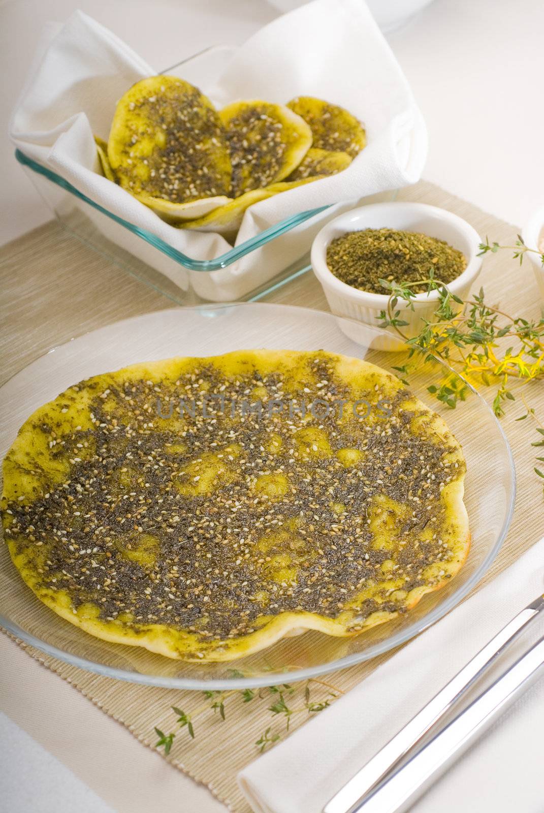 lebanese manouche or manoushe ,lebanese pizza with thyme and sesame seeds,zaatar, and extra virgin olive oil on top