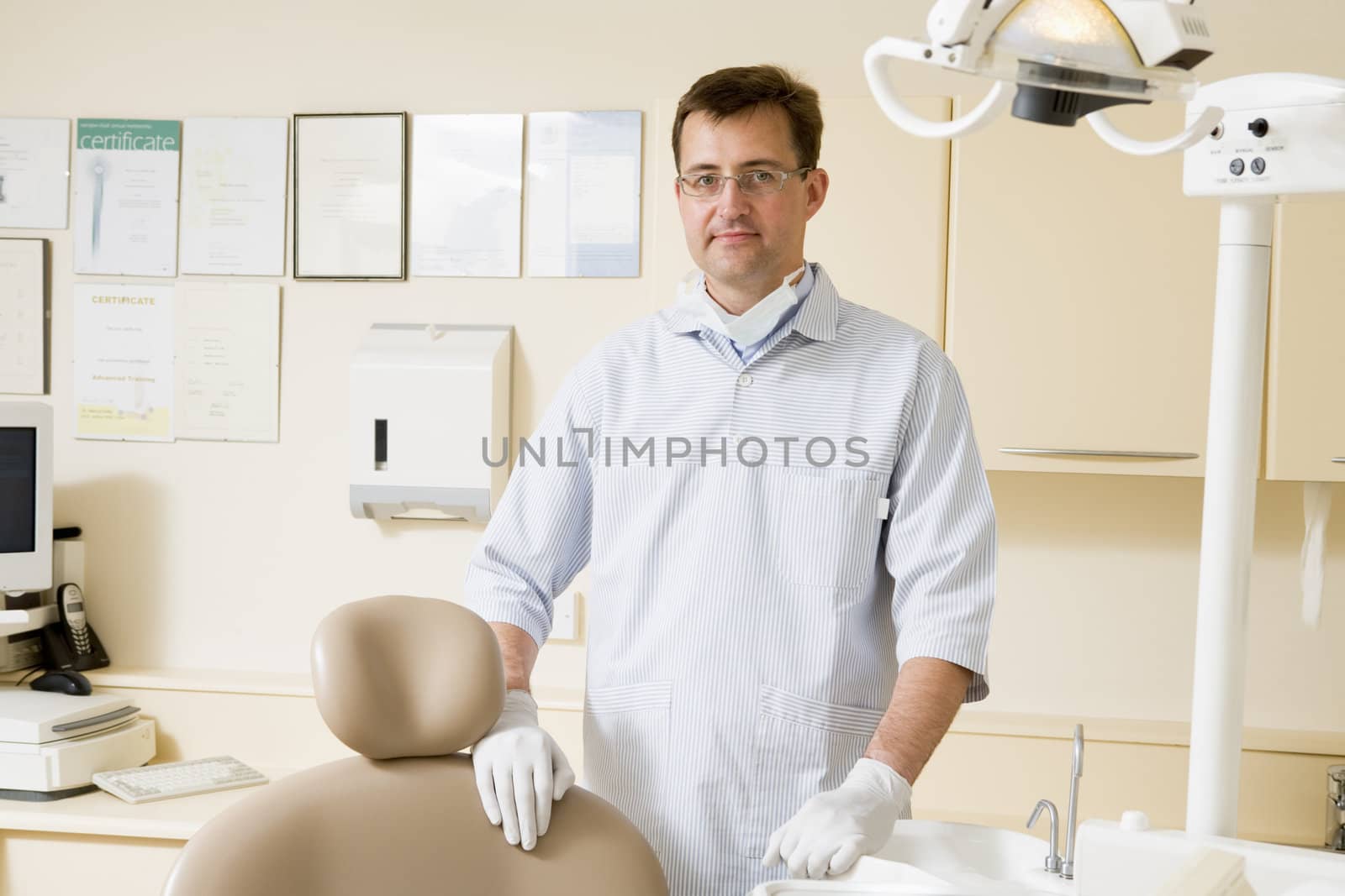 Dentist in exam room by MonkeyBusiness