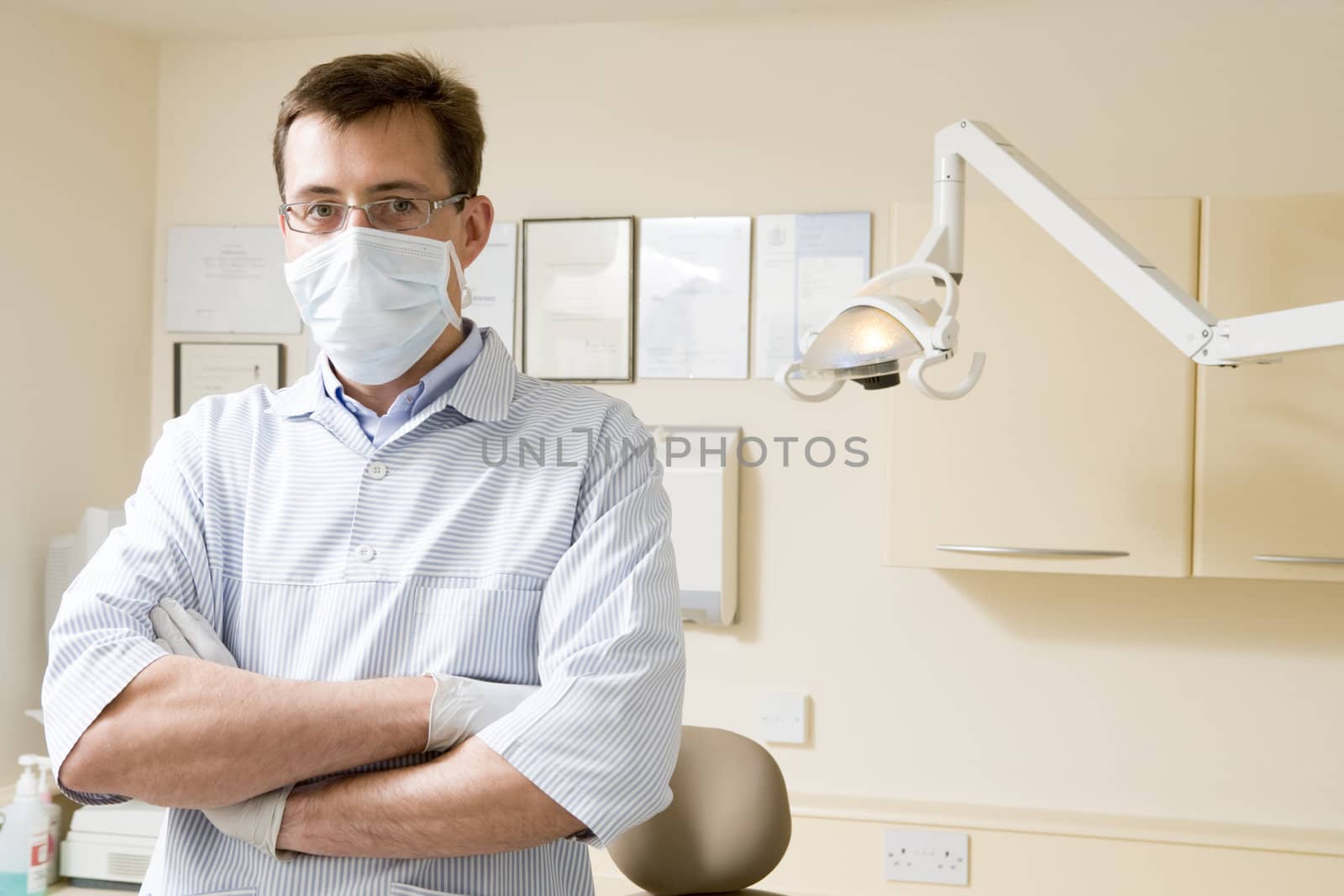 Dentist in exam room with mask on by MonkeyBusiness