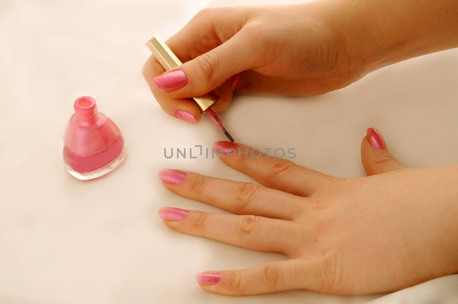 The woman imposes a varnish for manicure on nails
