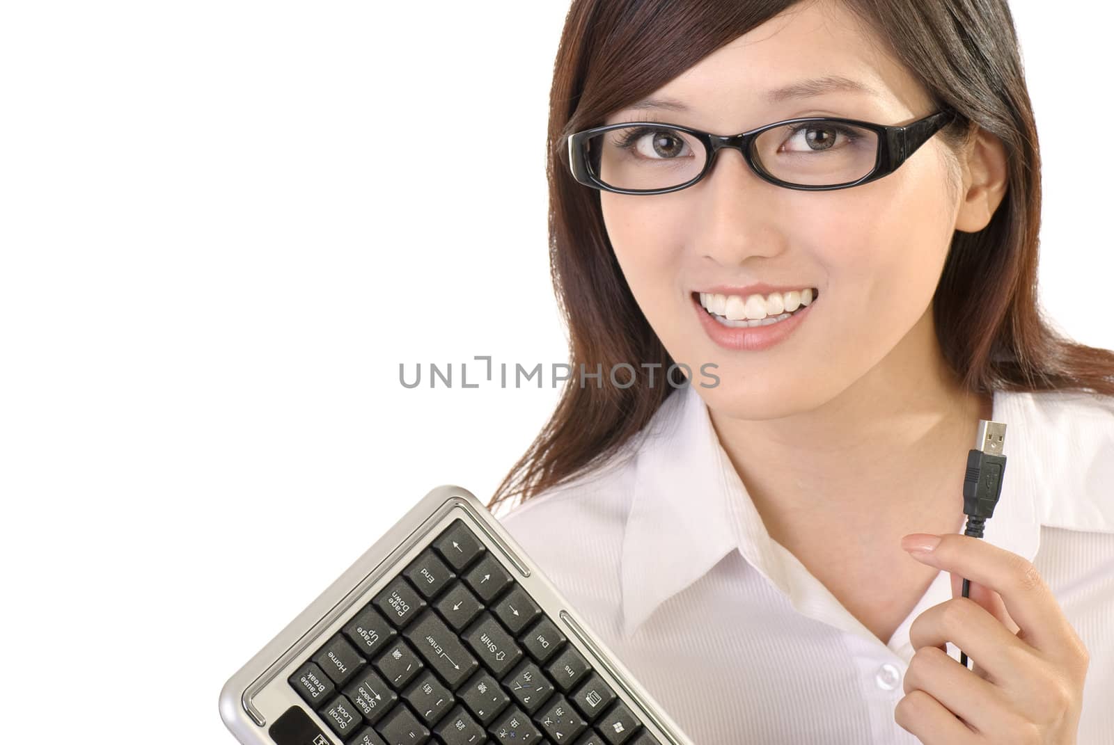 Businesswoman holding computer keyboard and smiling on white background.