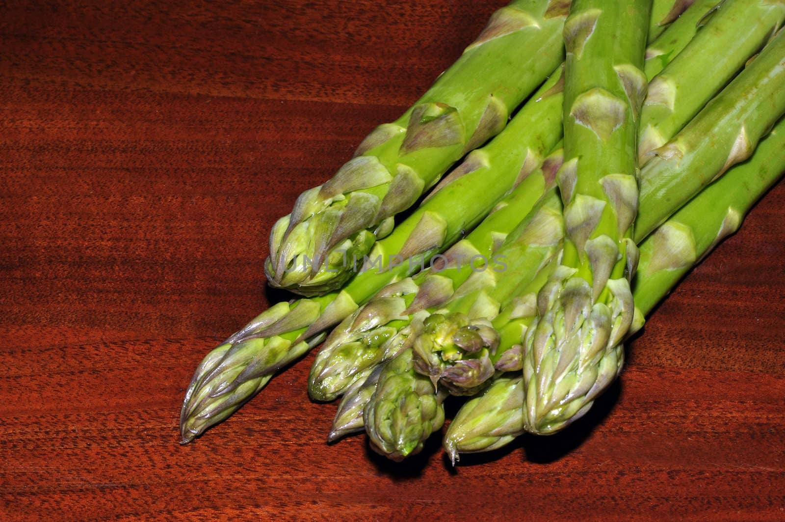 some asparagus on a table of dark wood