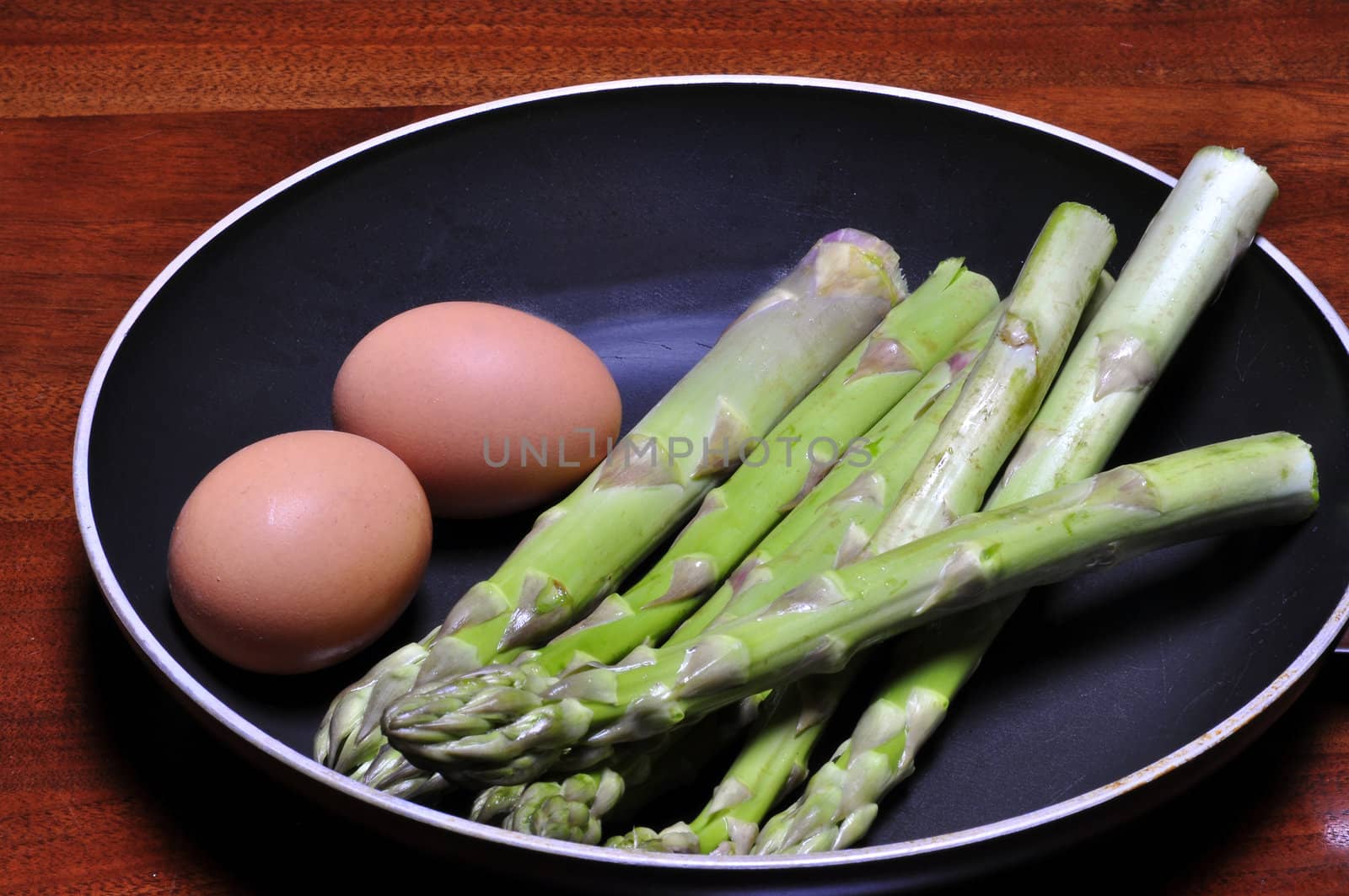 asparagus and eggs in a pan on a round table