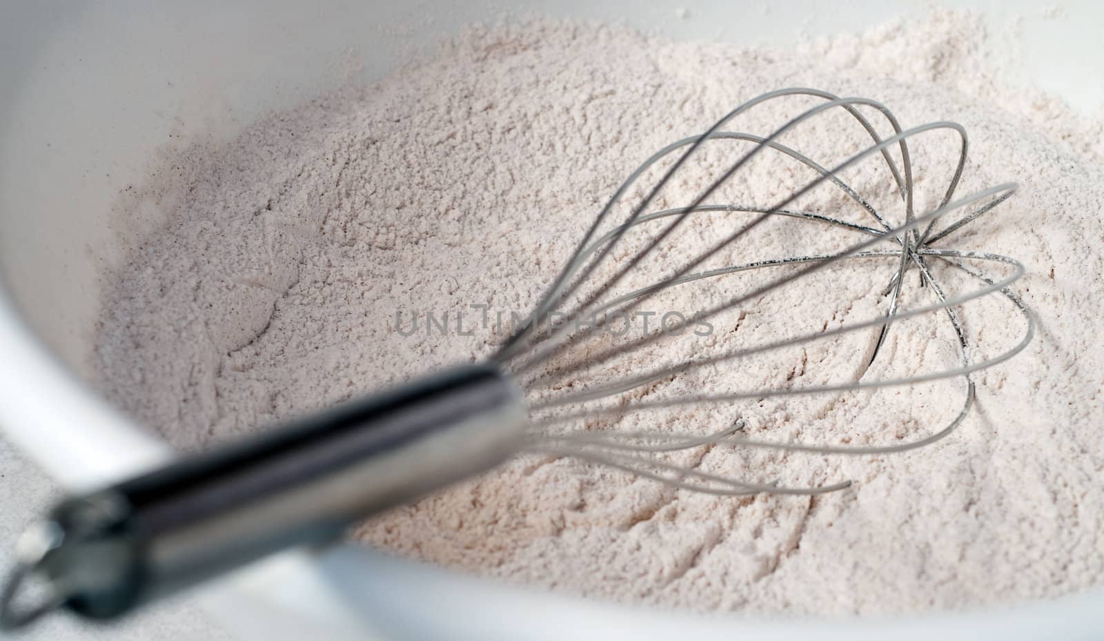 Dried muffin mix with a whisk about to mix it up