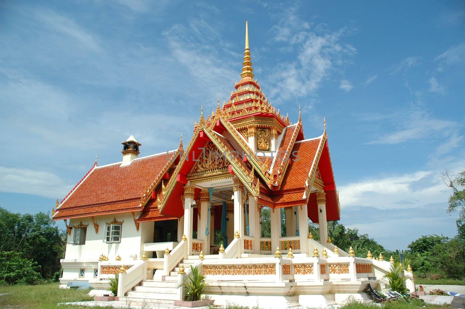 Temple taken in Thailand at a sunny day. The temple is white with a red roof.