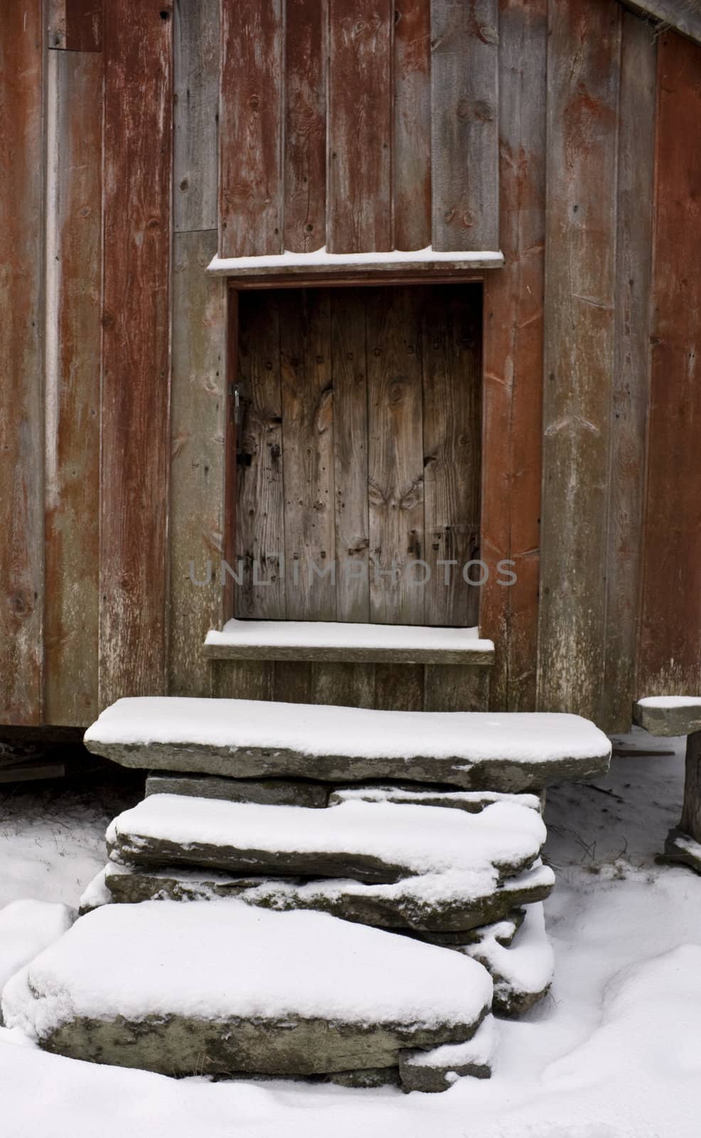 Snow clad stone stairs up to an old store house door