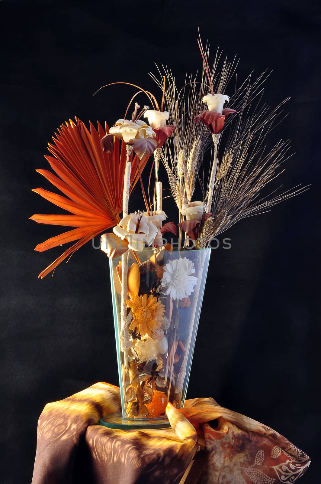 Composition of flowers in wood and Iin crystal vase on a black background