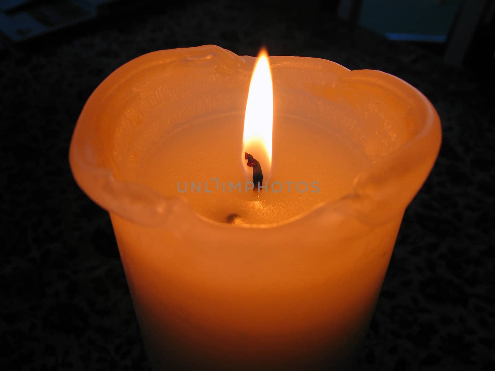 Big blowing beautiful orange candle isolated black background