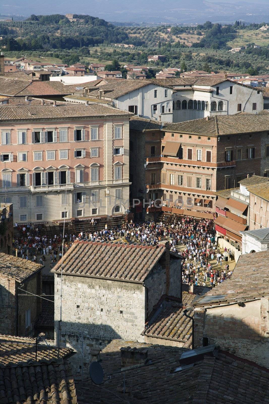 Rooftop view of Piazza del Campo with crowd gathered.