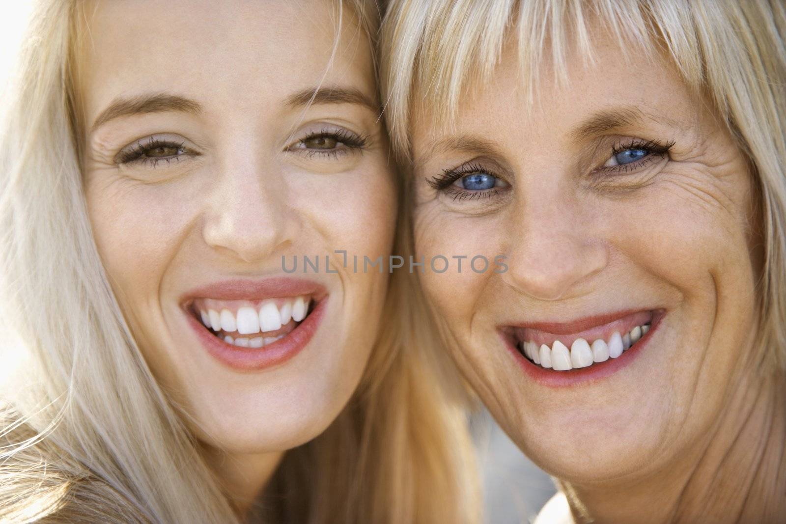 Portrait of Caucasian mother and daughter laughing and making eye contact.