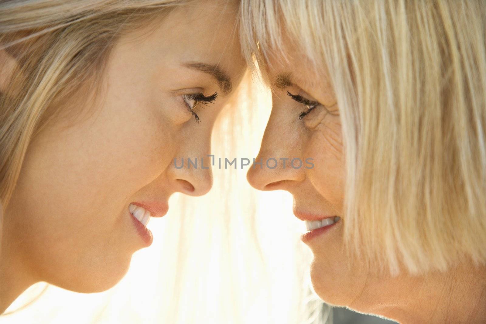 White mother and daughter face to face looking at each other.