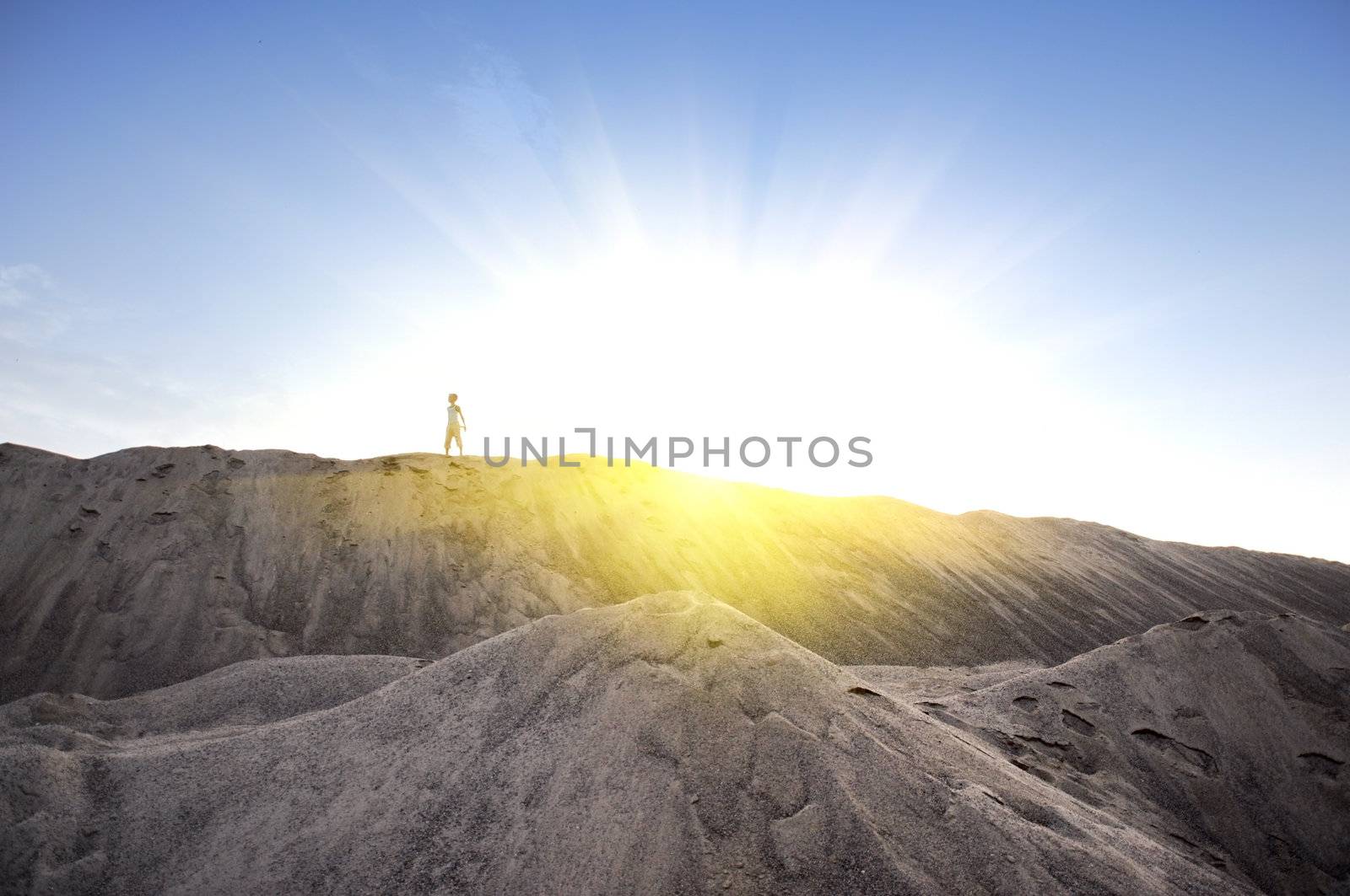  young man go up in sand desert in sundown