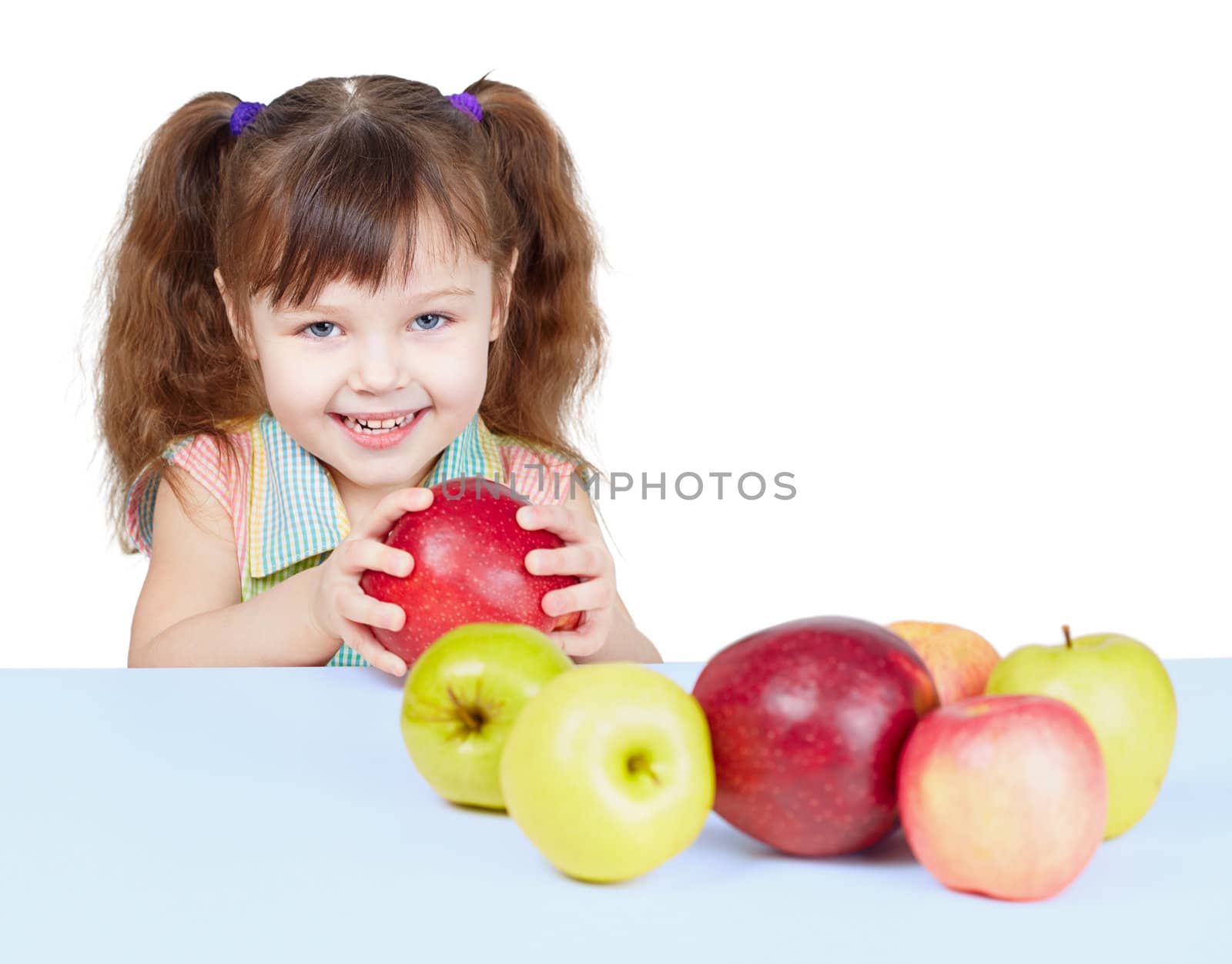 A little girl playing with fruits sitting at the table