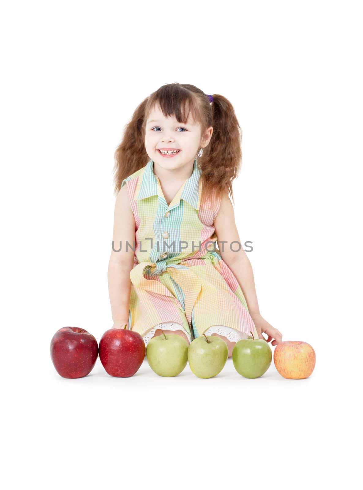 A happy girl playing with apples sitting on white background