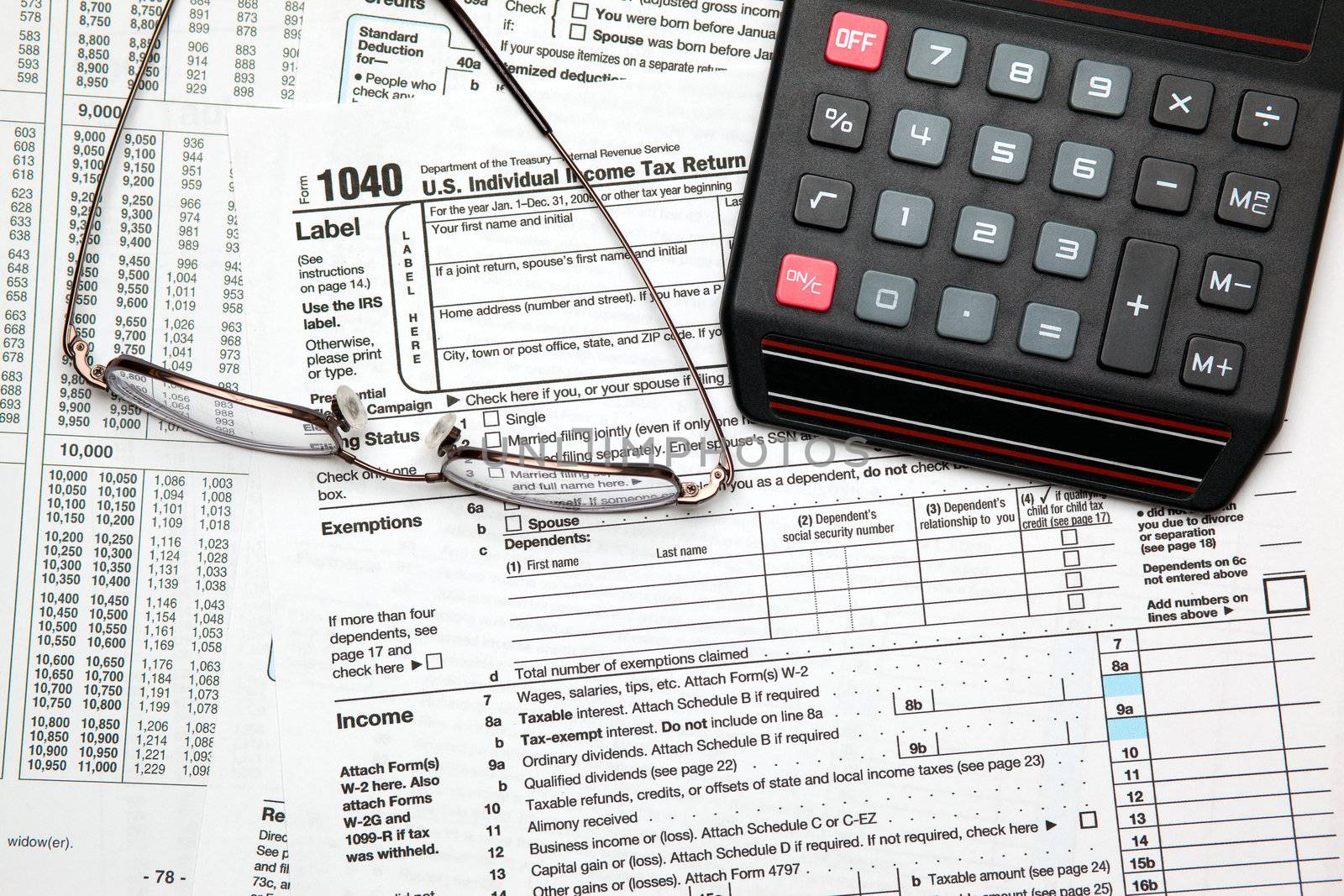 Tax time - Closeup of U.S. 1040 tax return with calculator and g by svanblar