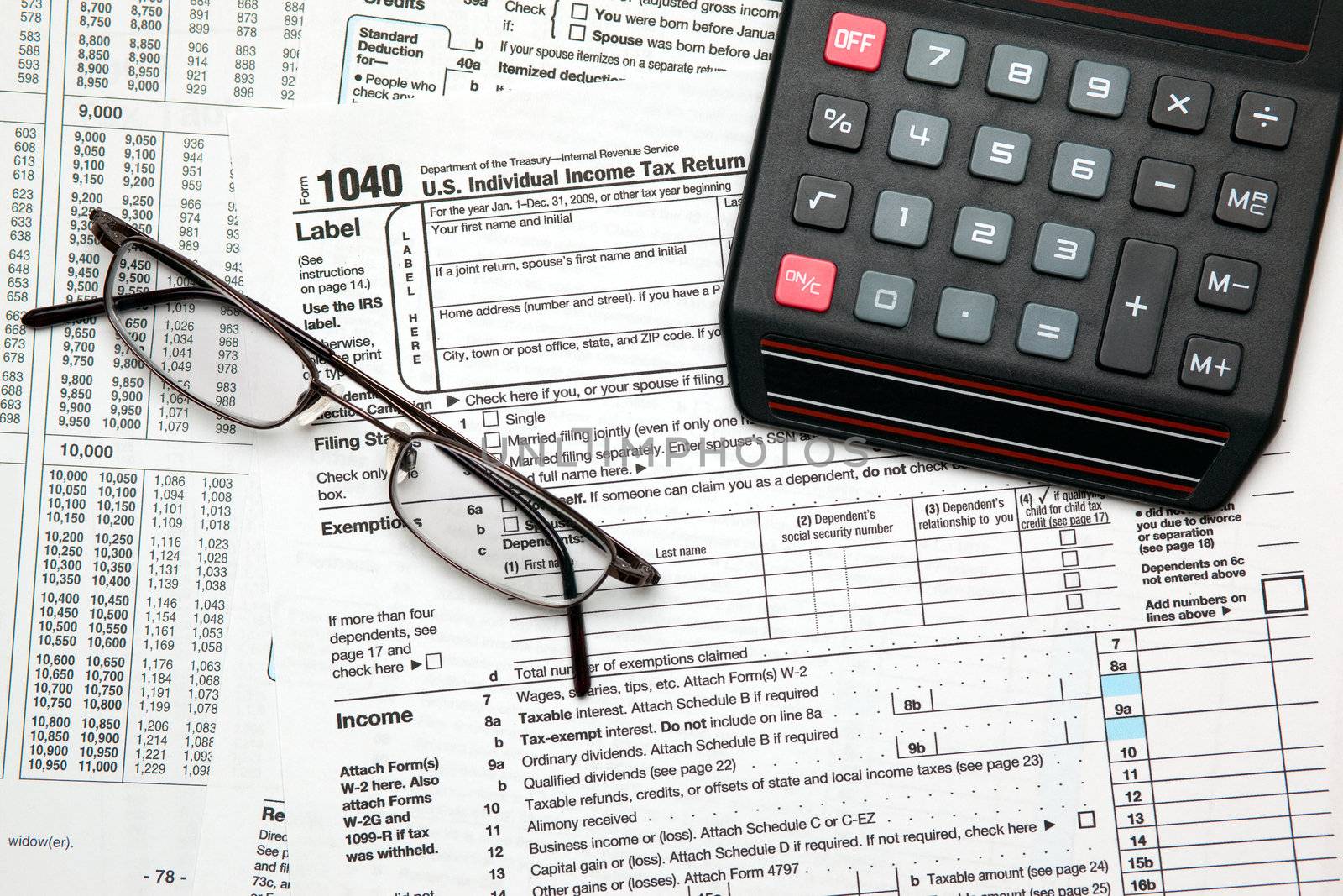 Tax time - Closeup of U.S. 1040 tax return with calculator and glasses