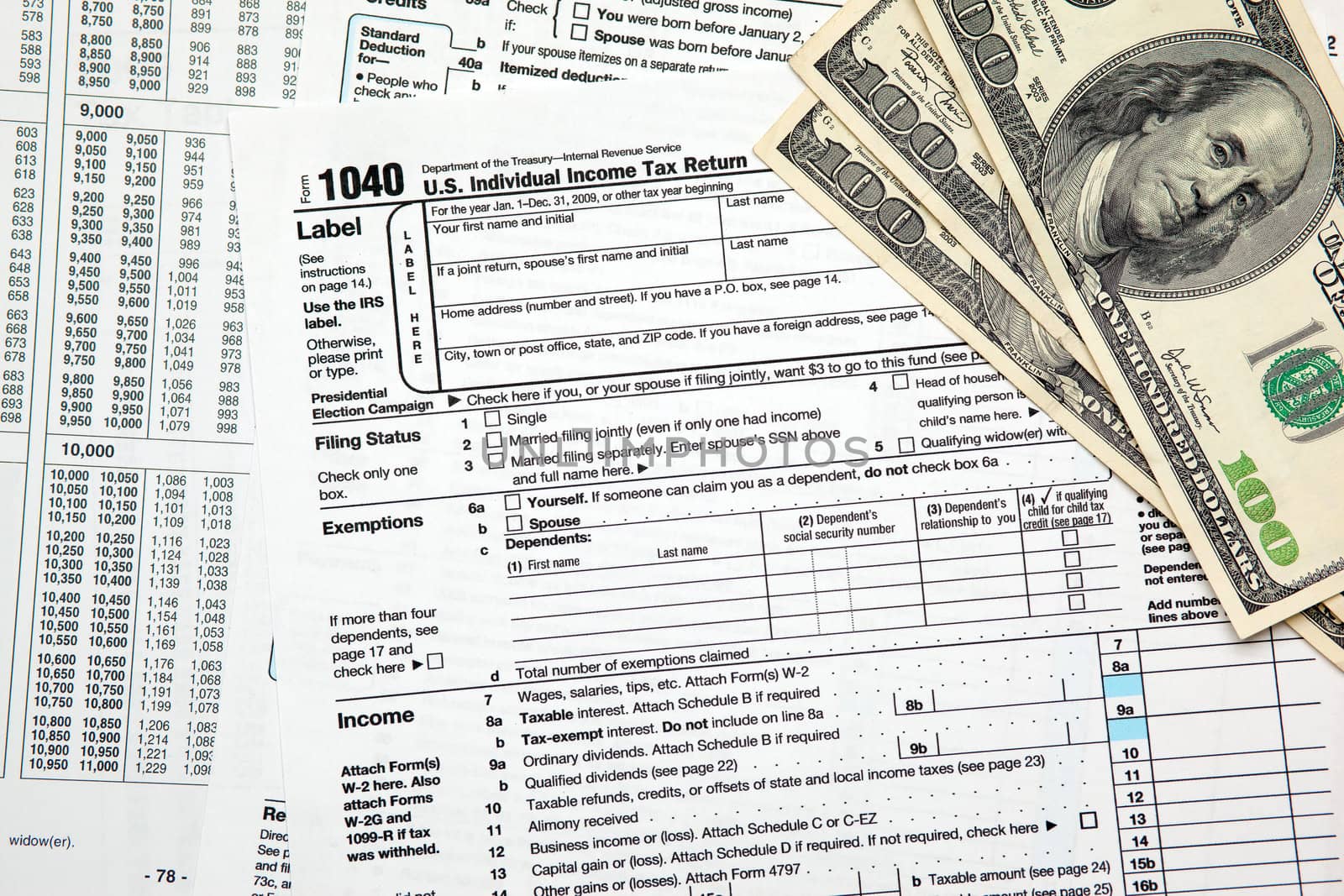 Tax time - Closeup of U.S. 1040 tax return with $100 bills