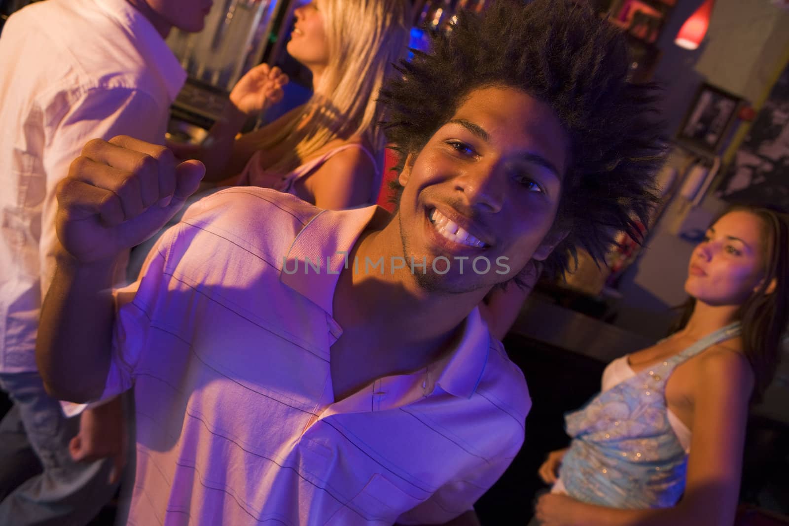 Young people dancing in a bar  by MonkeyBusiness