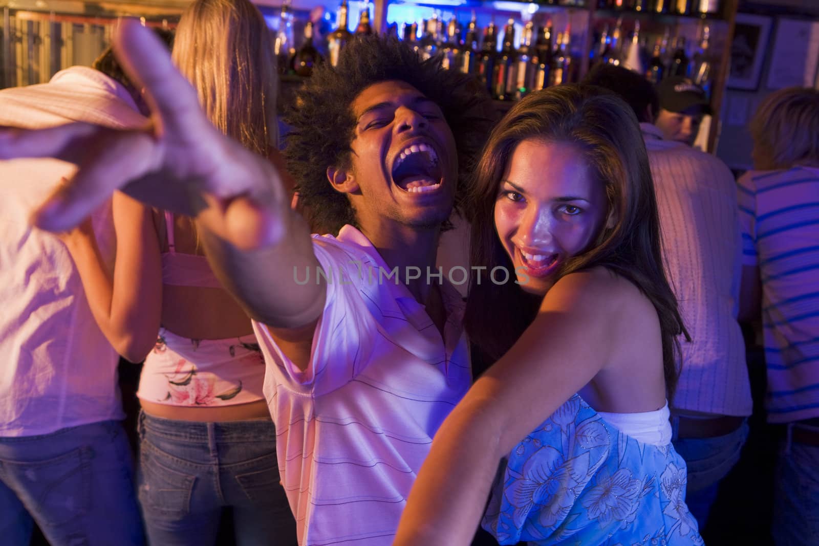 Young people dancing in a bar  by MonkeyBusiness