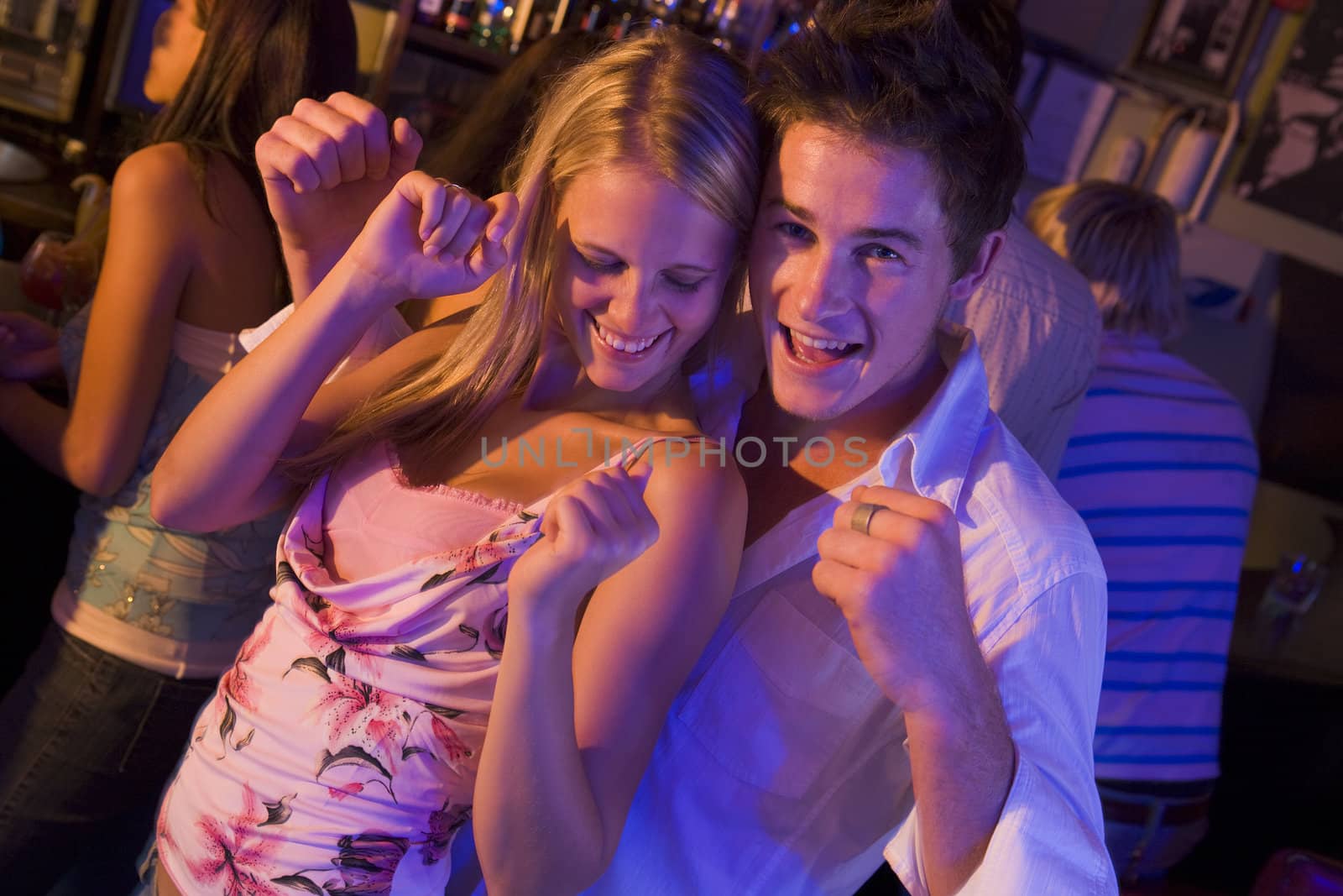 Young people dancing in a bar  by MonkeyBusiness