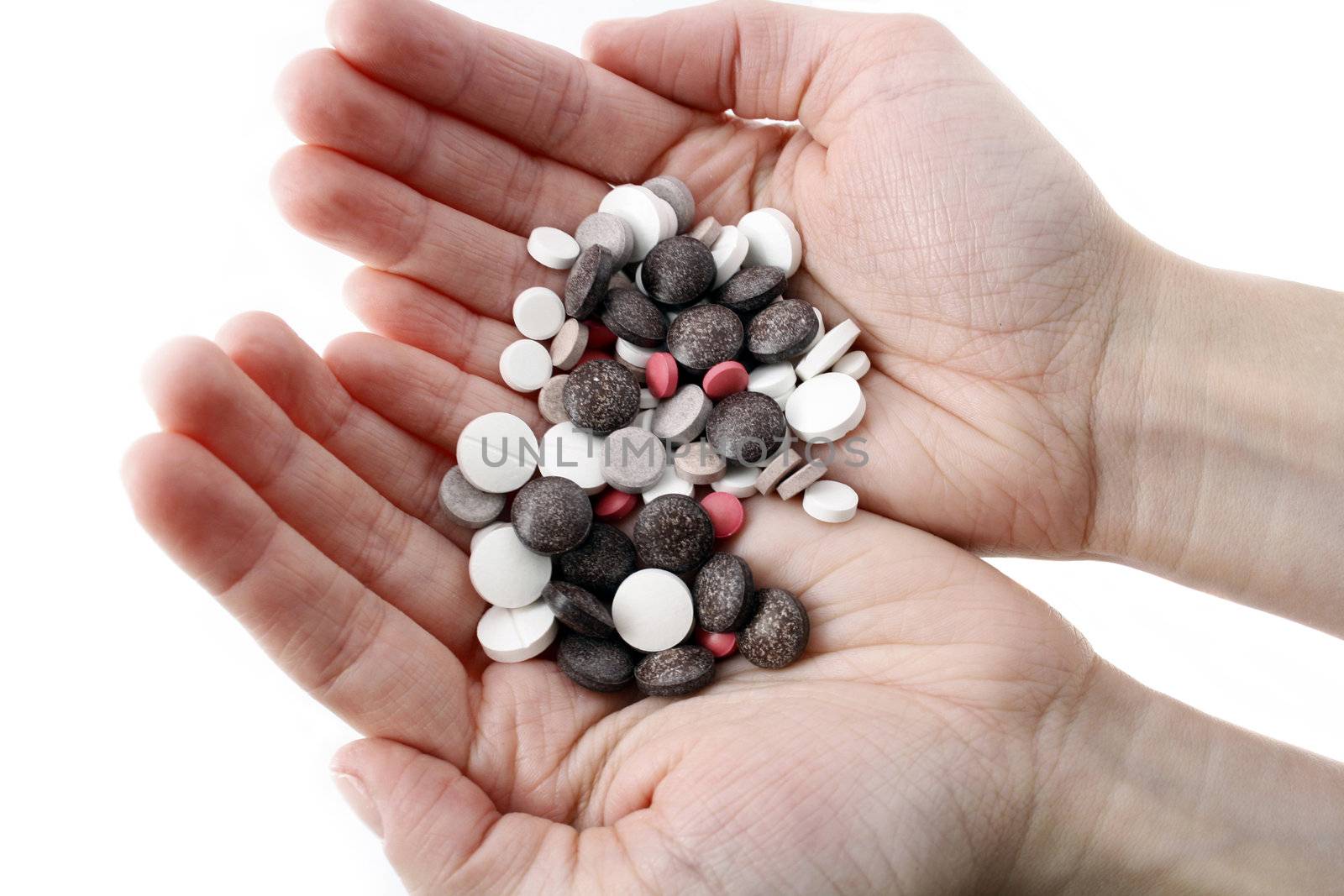 Hands with variety of pills by magraphics