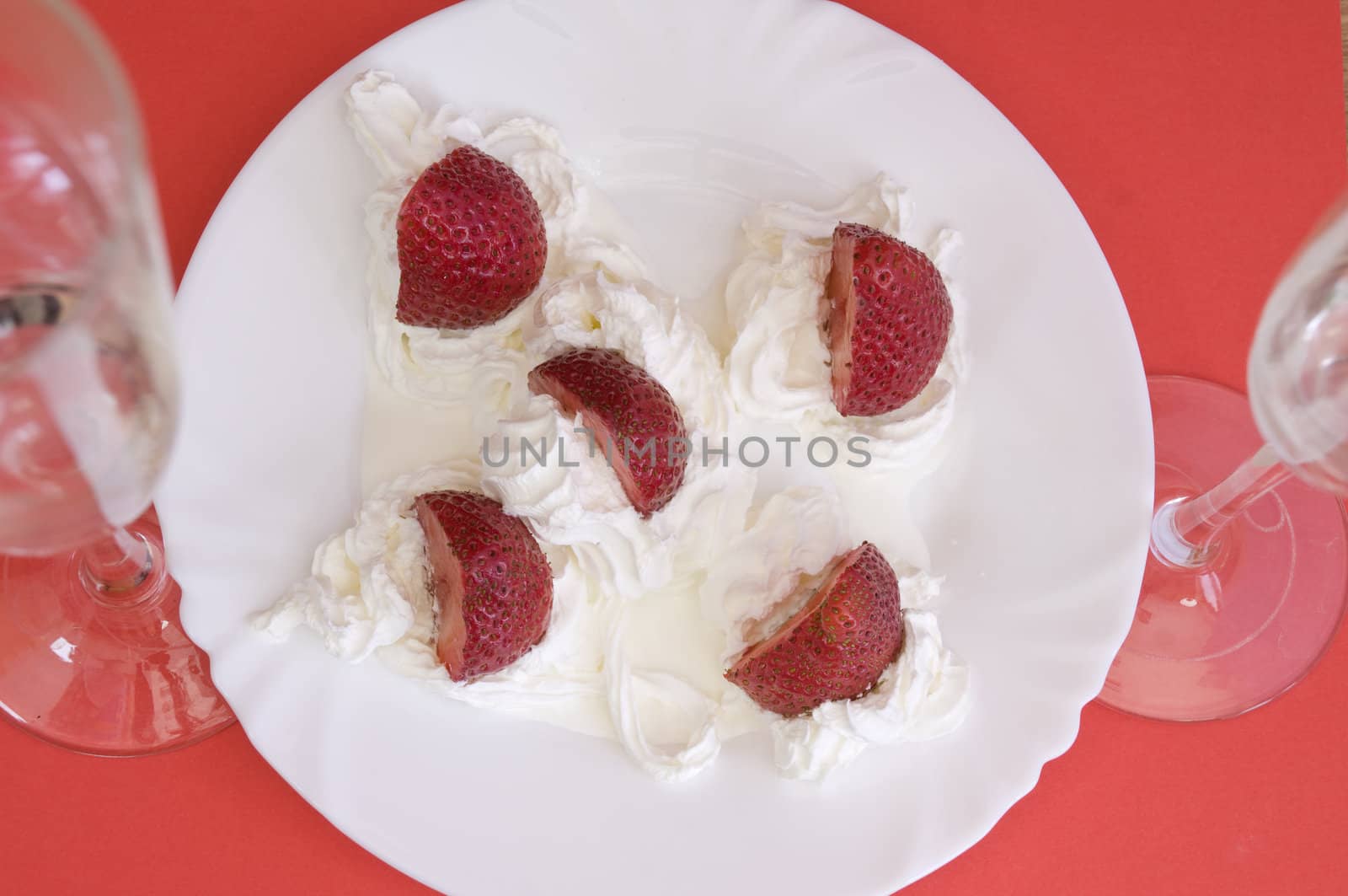 fresh strawberries,  light cream and champagne on red background