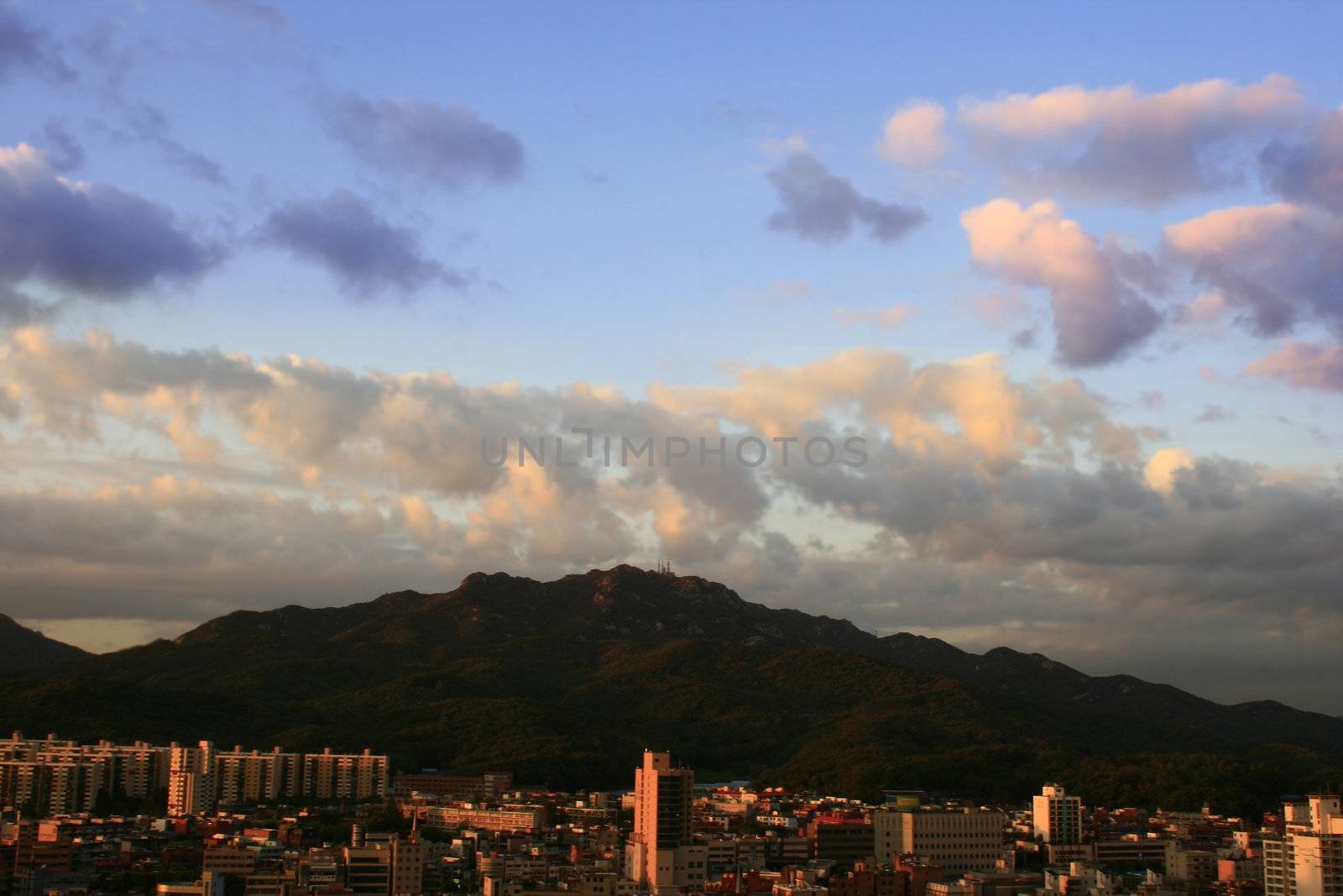 Sunset over urban scene with mountain in Anyang City Korea
