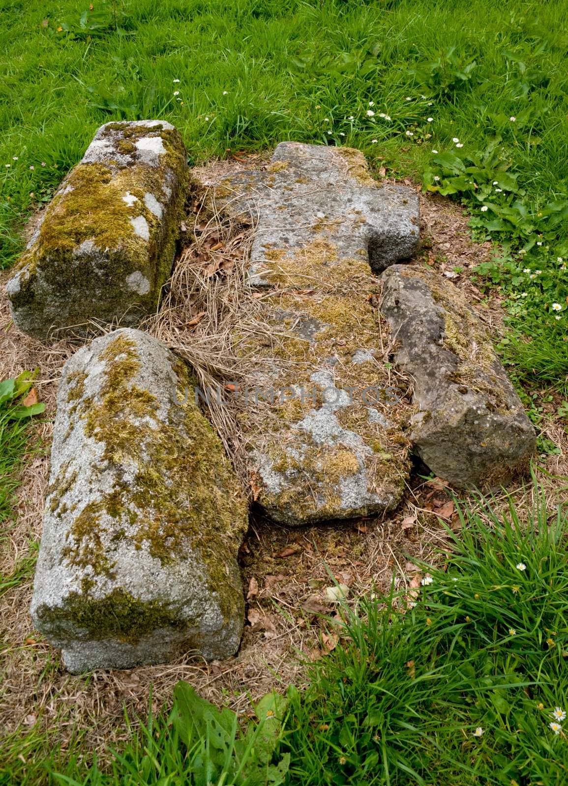 Old medieval stone cross, lying broken and fallen on the grass at Killevy Churches, County Armagh, Northern Ireland