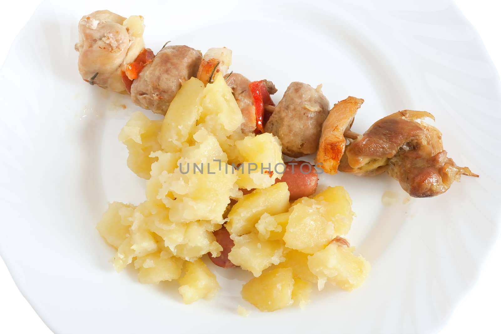 detail of baked pork kebab with potatoes on a dish