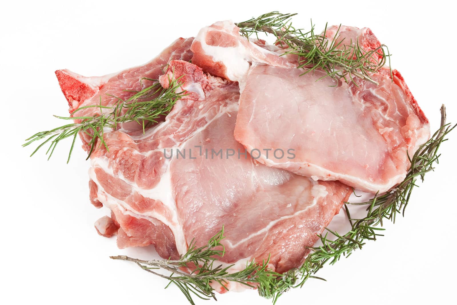 three raw pork steaks with rosemary isolated on white background
