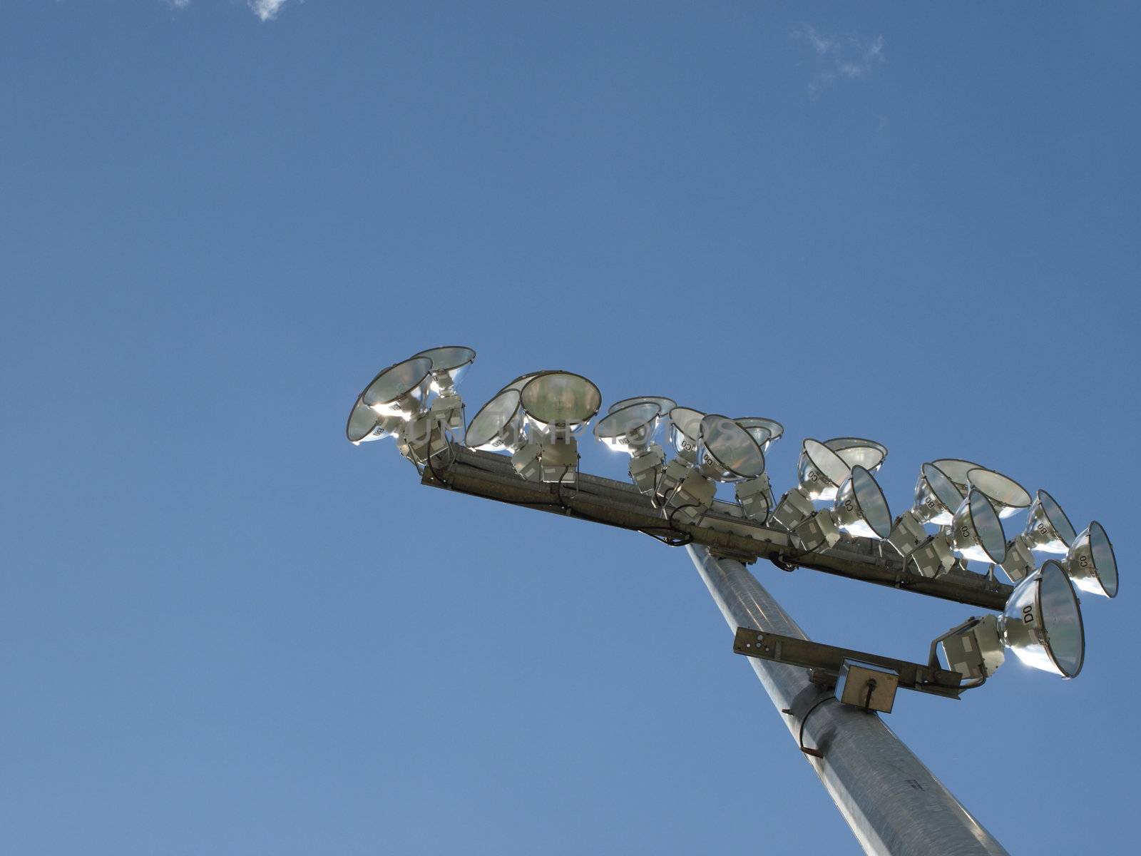 A tall light pole a sports stadium, not needed on this clear day.