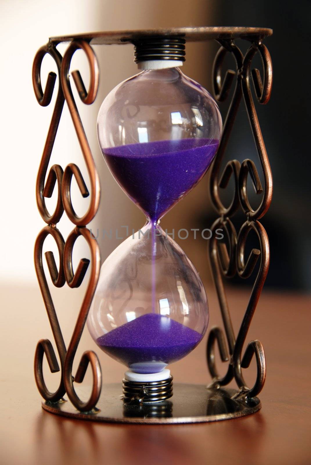 sand clock on desk closeup, time passing concept