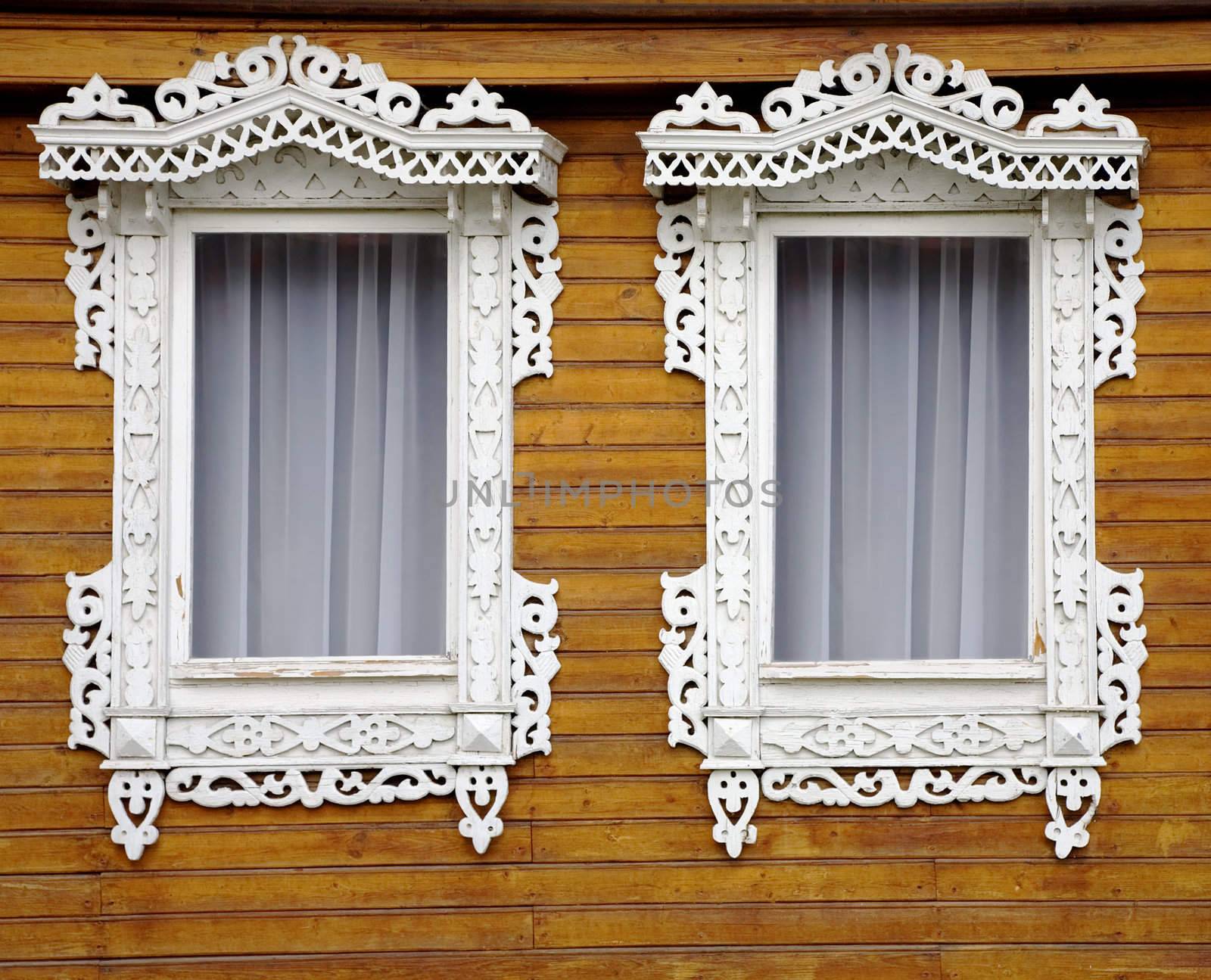 Two windows from old wooden yellow wall