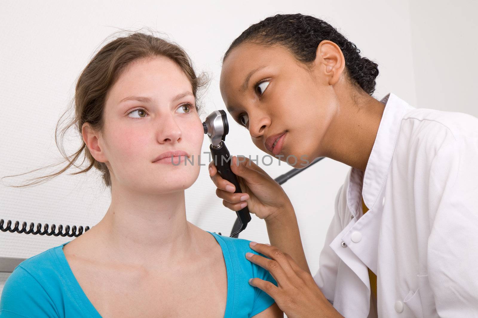 Doctor peering into her patients ear with an instrument
