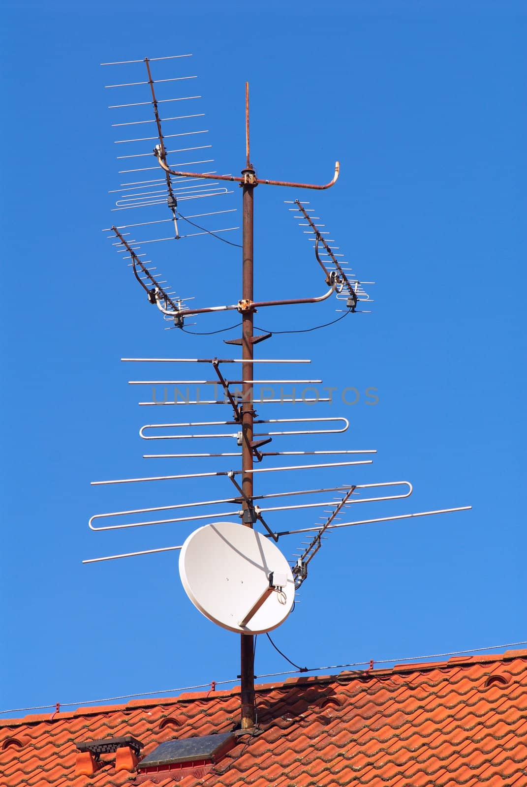 Photo of a roof of the suburban house with the attached aerials of communication