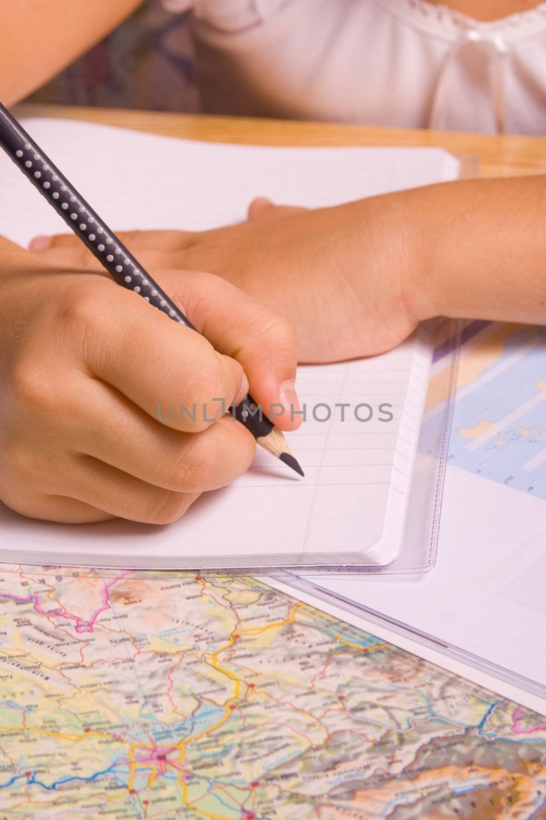 Girl doing her homework by writing in notebook.