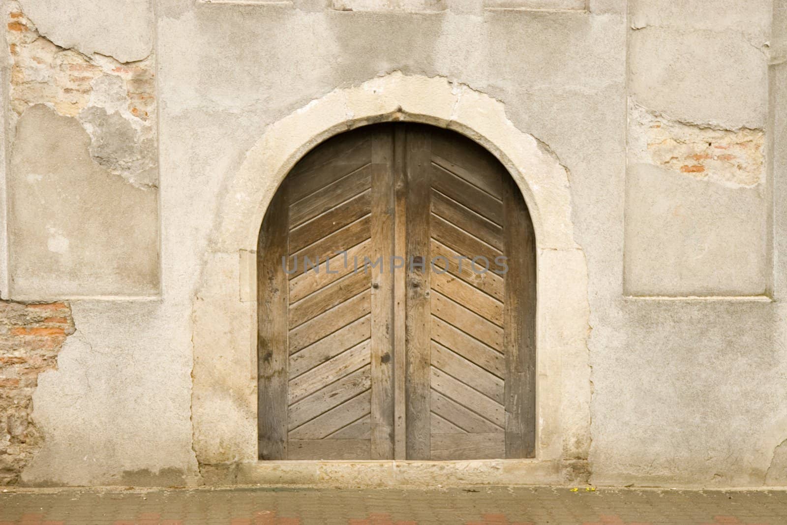 front view of wooden door and ancient wall