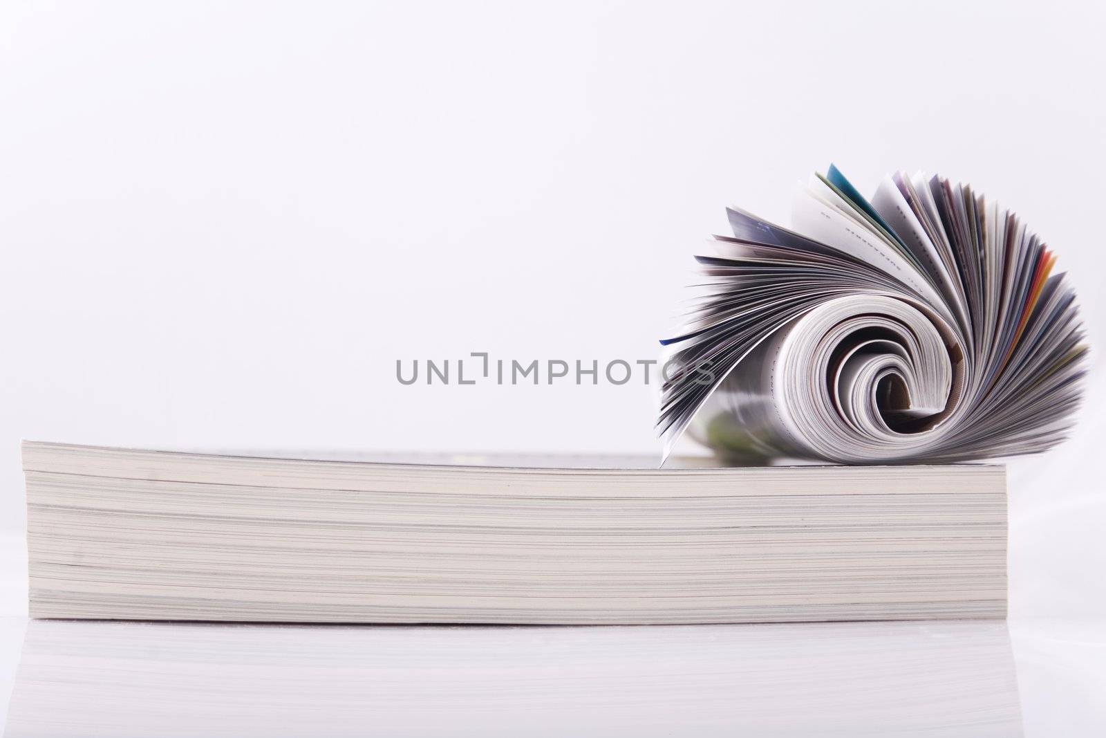Magazine Roll isolated on white, on a bunch of other magazines