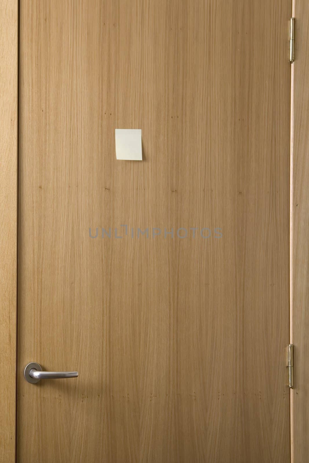 wooden door with a post-it stick on it