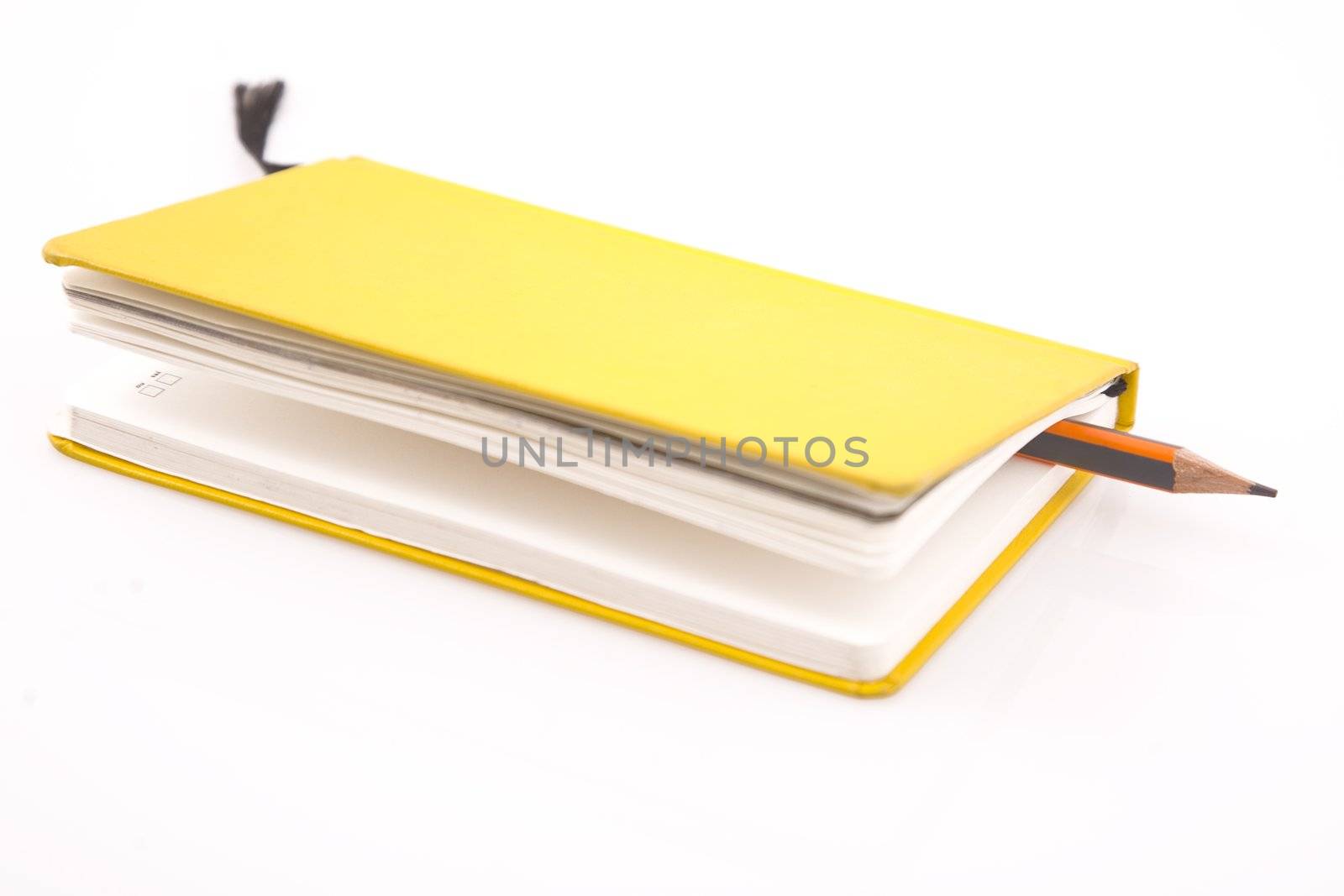 yellow notebook and pencil on  white background