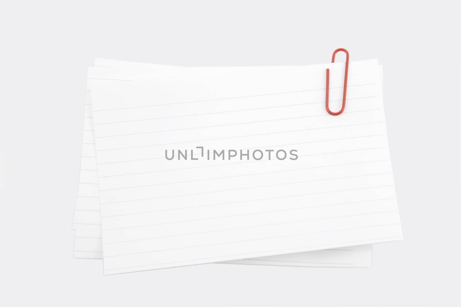 three pieces of line paper with a red clip (with clipping path)