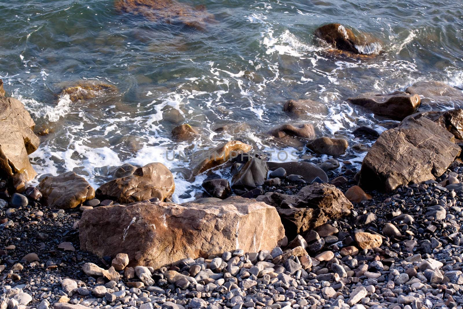Crimea coast in summertime: stones in water
