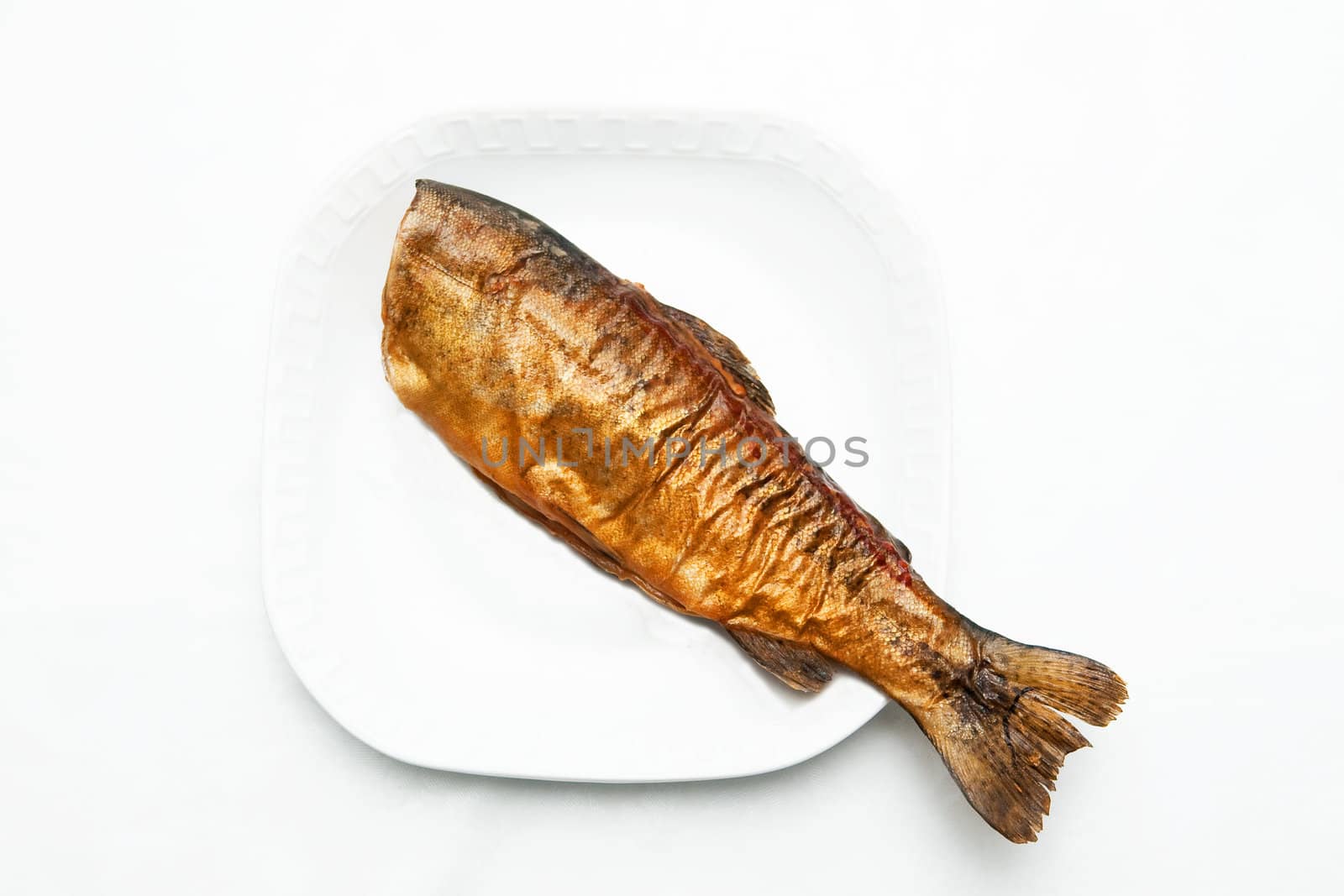 A smoked fish on the white plate