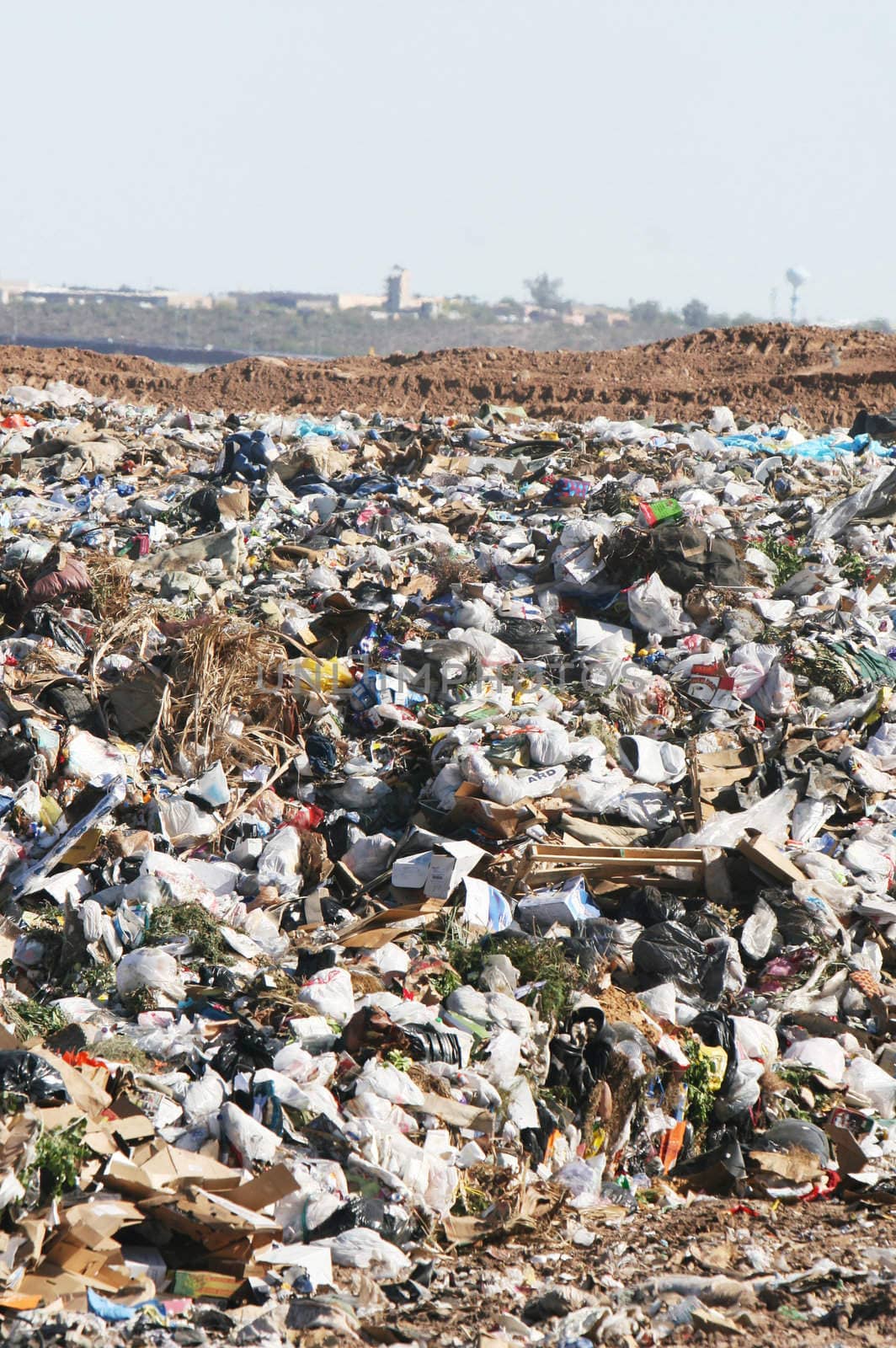 A giant mound of trash in a landfill. All trademarks and logos digitally removed.