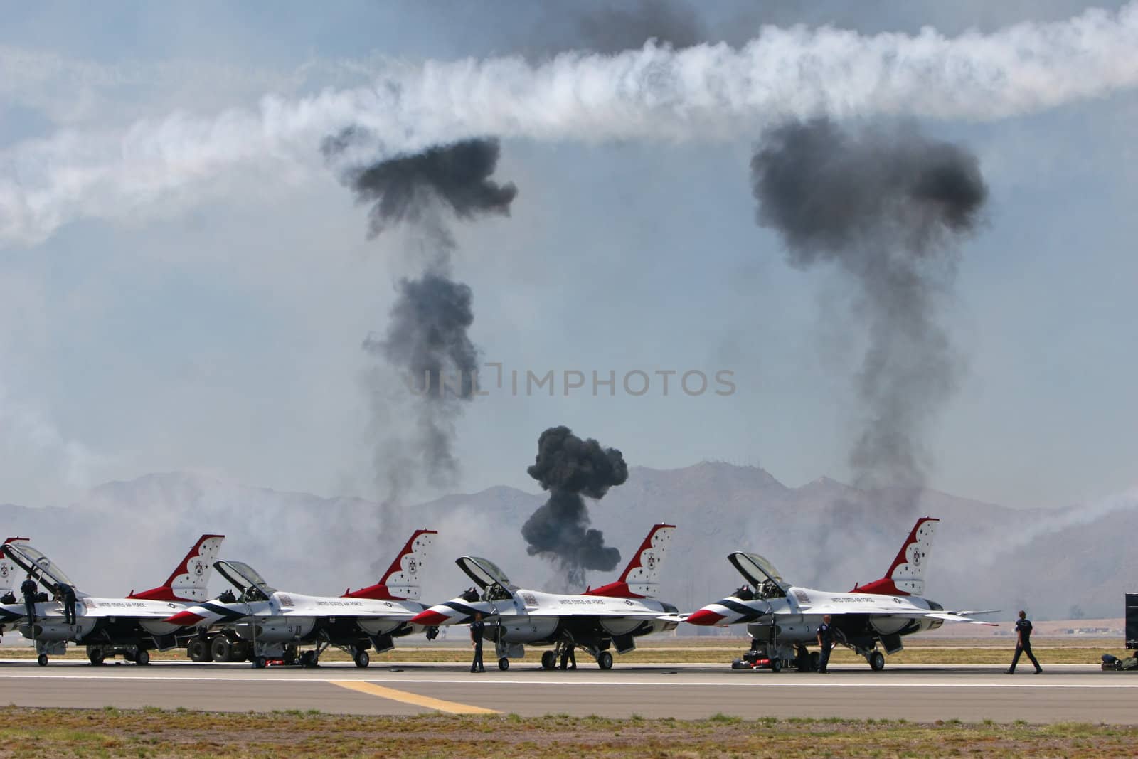 American pilots prepare their jets as explosions happen in the background