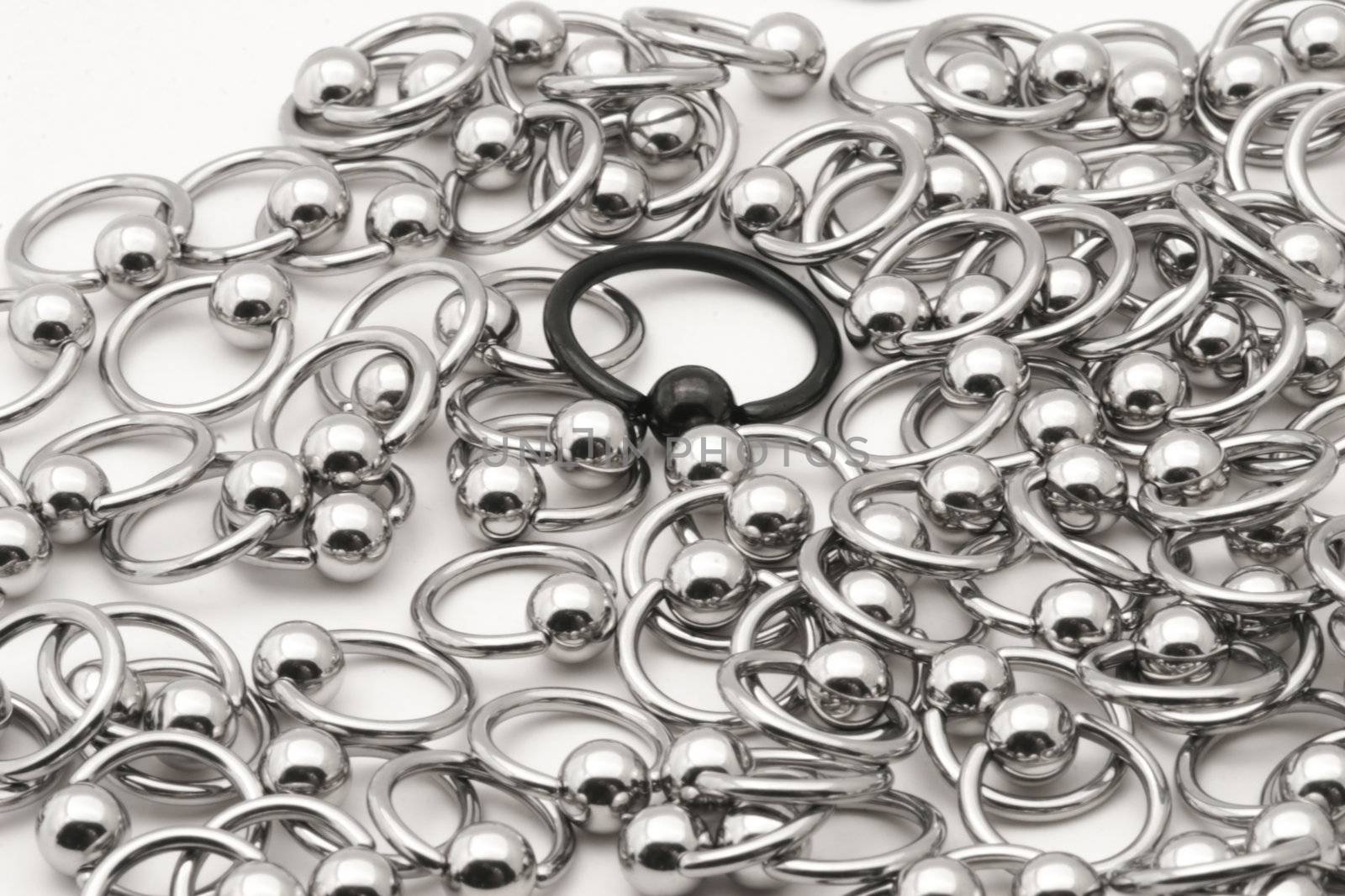 Lynching the Outsider. A lone black captive ring is surrounded by silver rings.